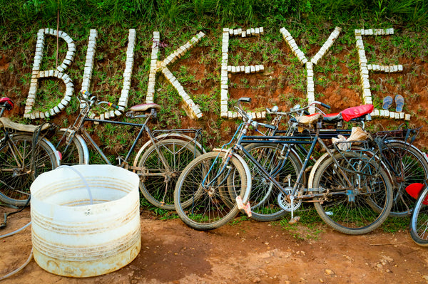 BUKEYE-Schriftzug aus weißen Steinen an der Washing Station, davor Fahrräder der Kaffeebauern – Foto: Long Miles Coffee